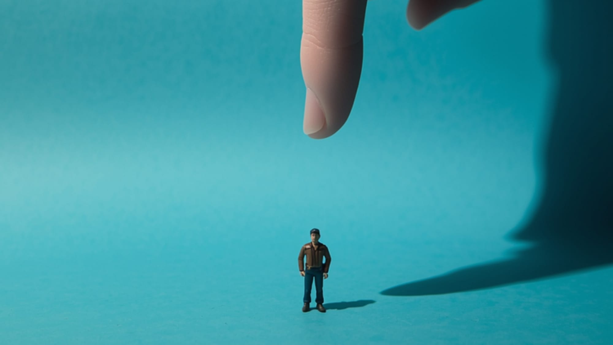 A small figure and the large shadow of a hand, a metaphor for the influence of a major platform