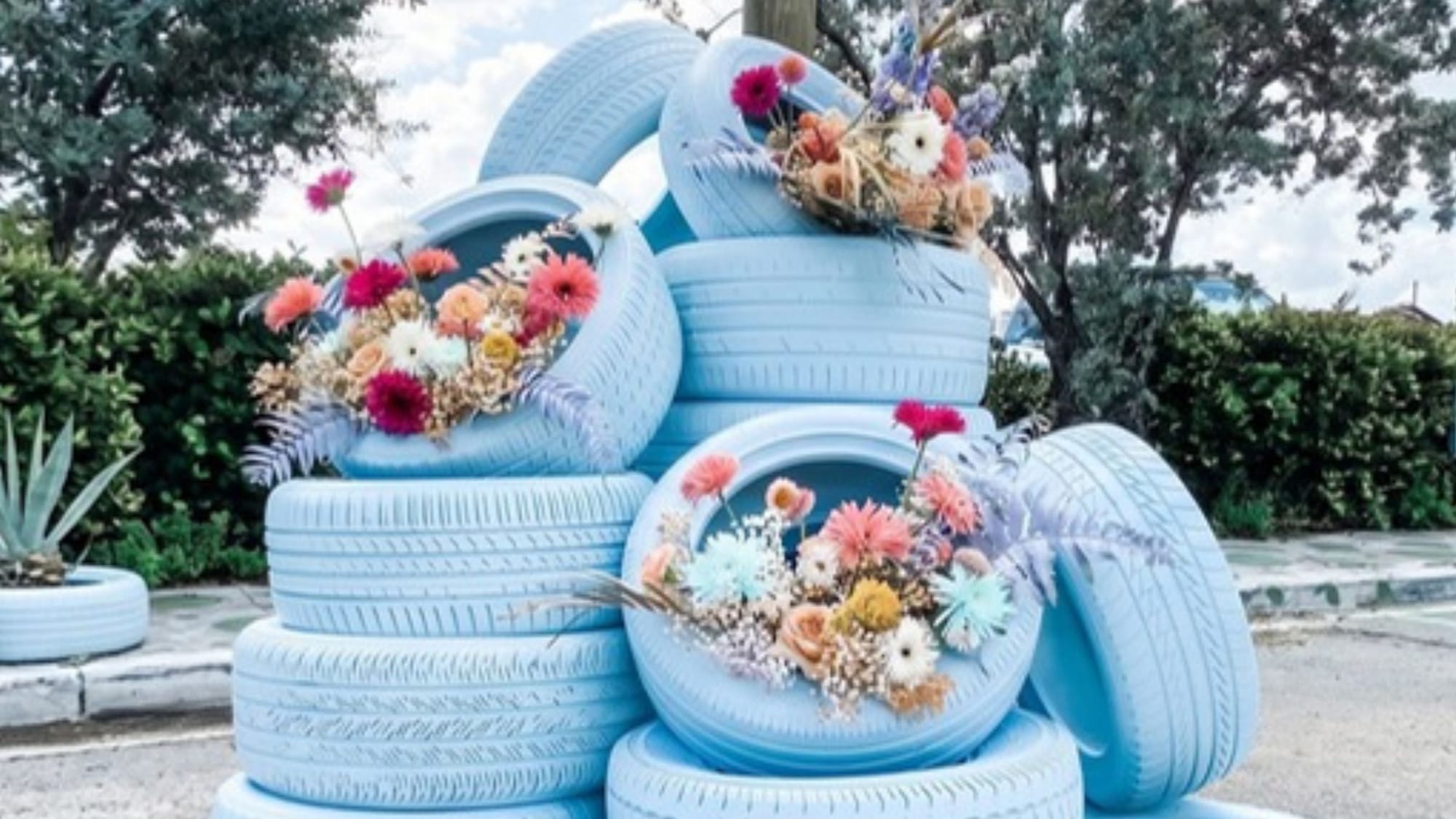 Old tyres repainted blue, stacked and planted with flowers