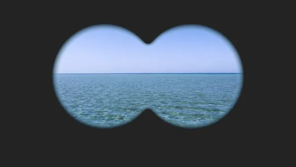 Pohled dalekohledem na mořský horizont, dva kruhové výřezy nad klidnou hladinou