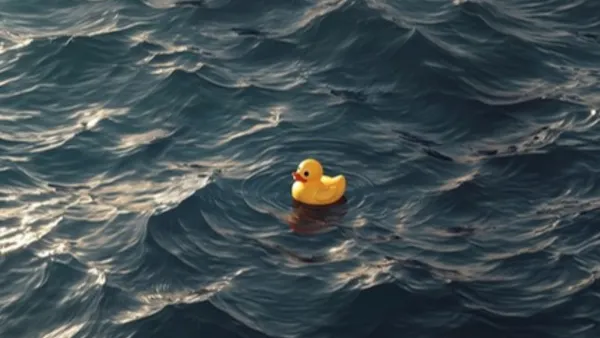 Žlutá gumová kachnička na hladině rozlehlého tmavého oceánu