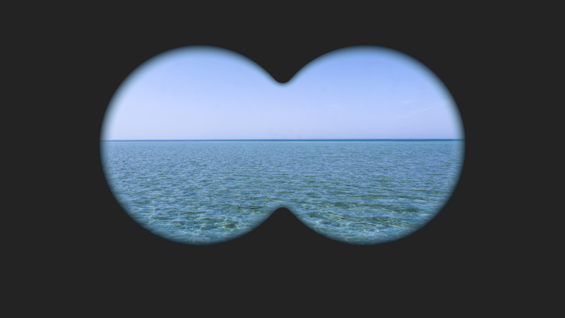 Pohled dalekohledem na mořský horizont, dva kruhové výřezy nad klidnou hladinou
